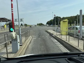French motorway toll station with barrier and traffic light at Sainte-Aulde, showing péage lanes and yellow payment terminal, captured on August 14, 2025